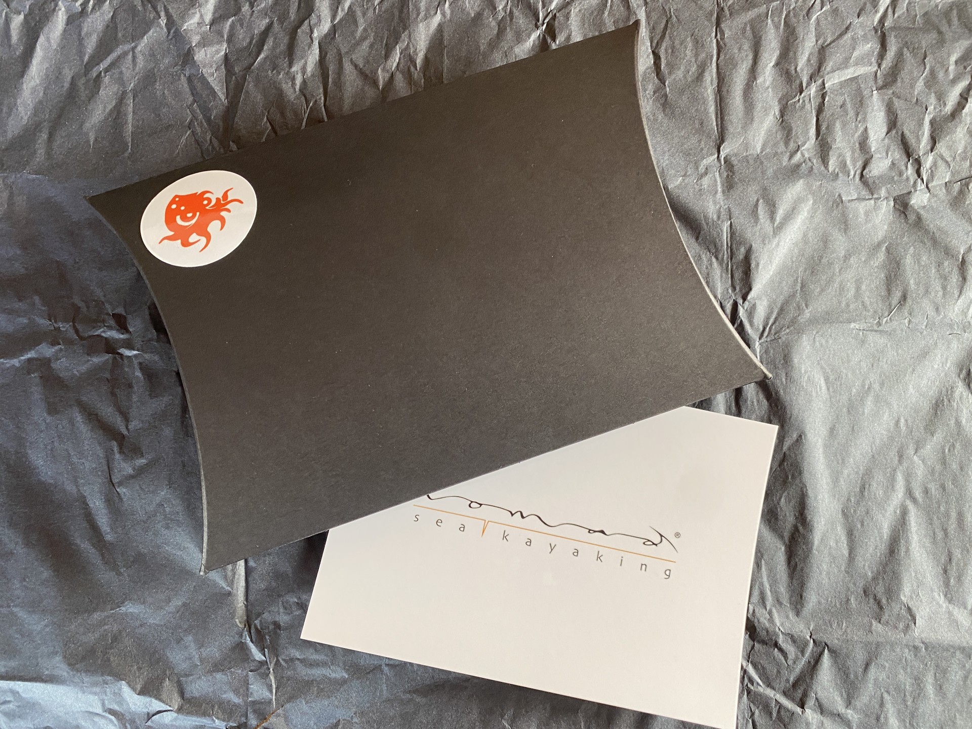 Xmas gift certificate voucher in black gift wrapping with orange accents.