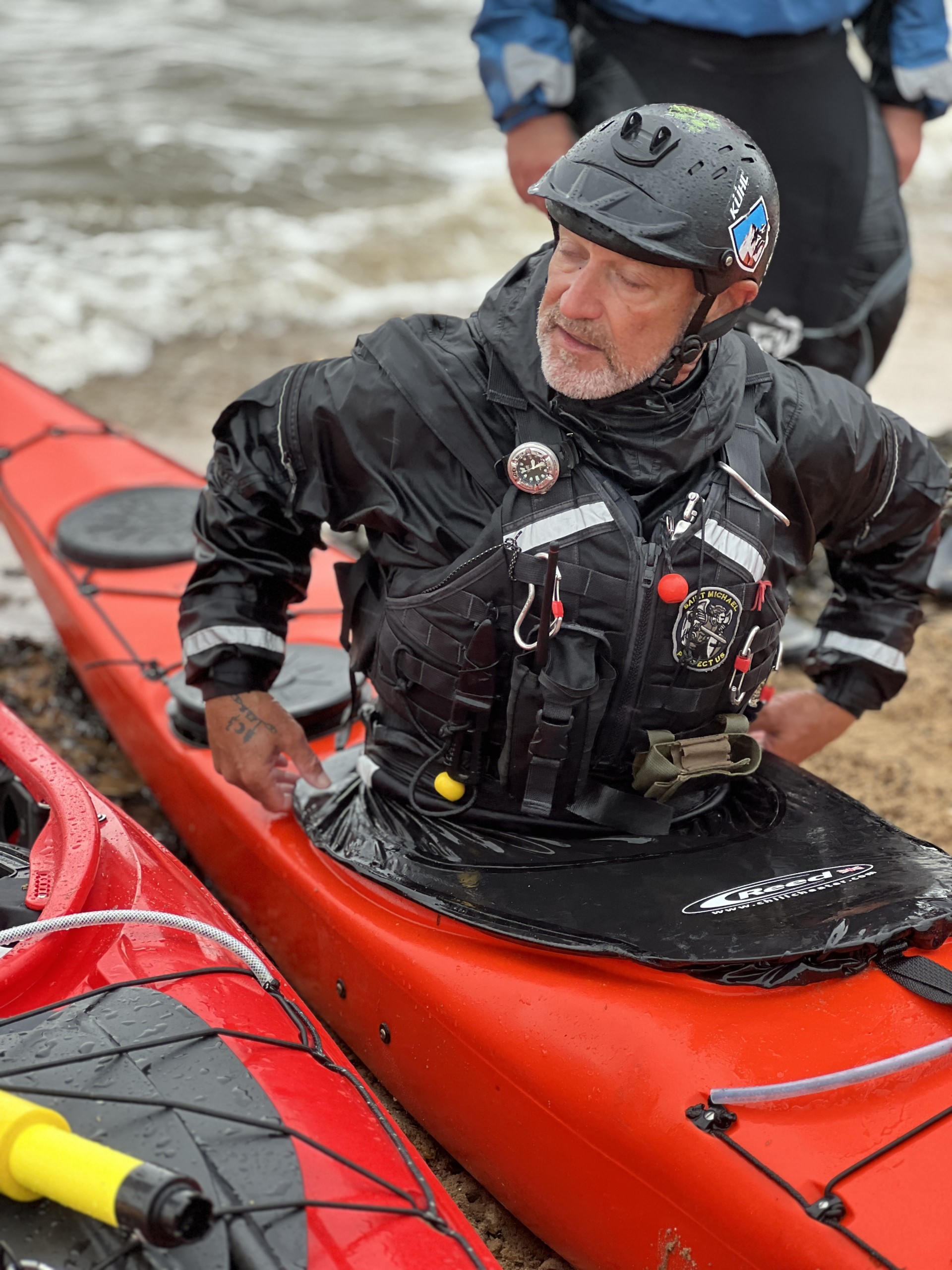 Putting on a spraydeck with NOMAD Sea Kayaking.