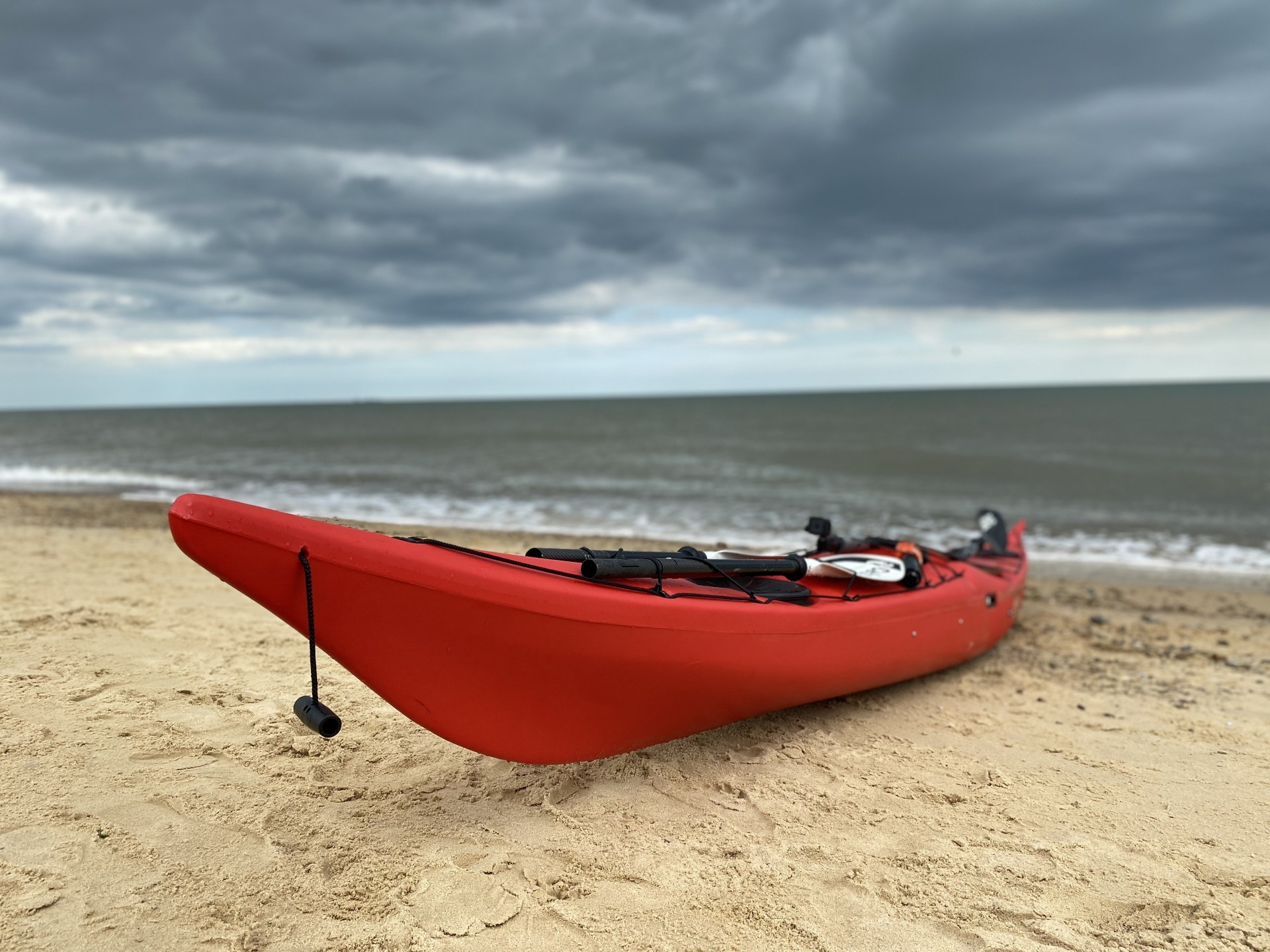 Red NDK roto-moulded sea kayak on a sandy beach