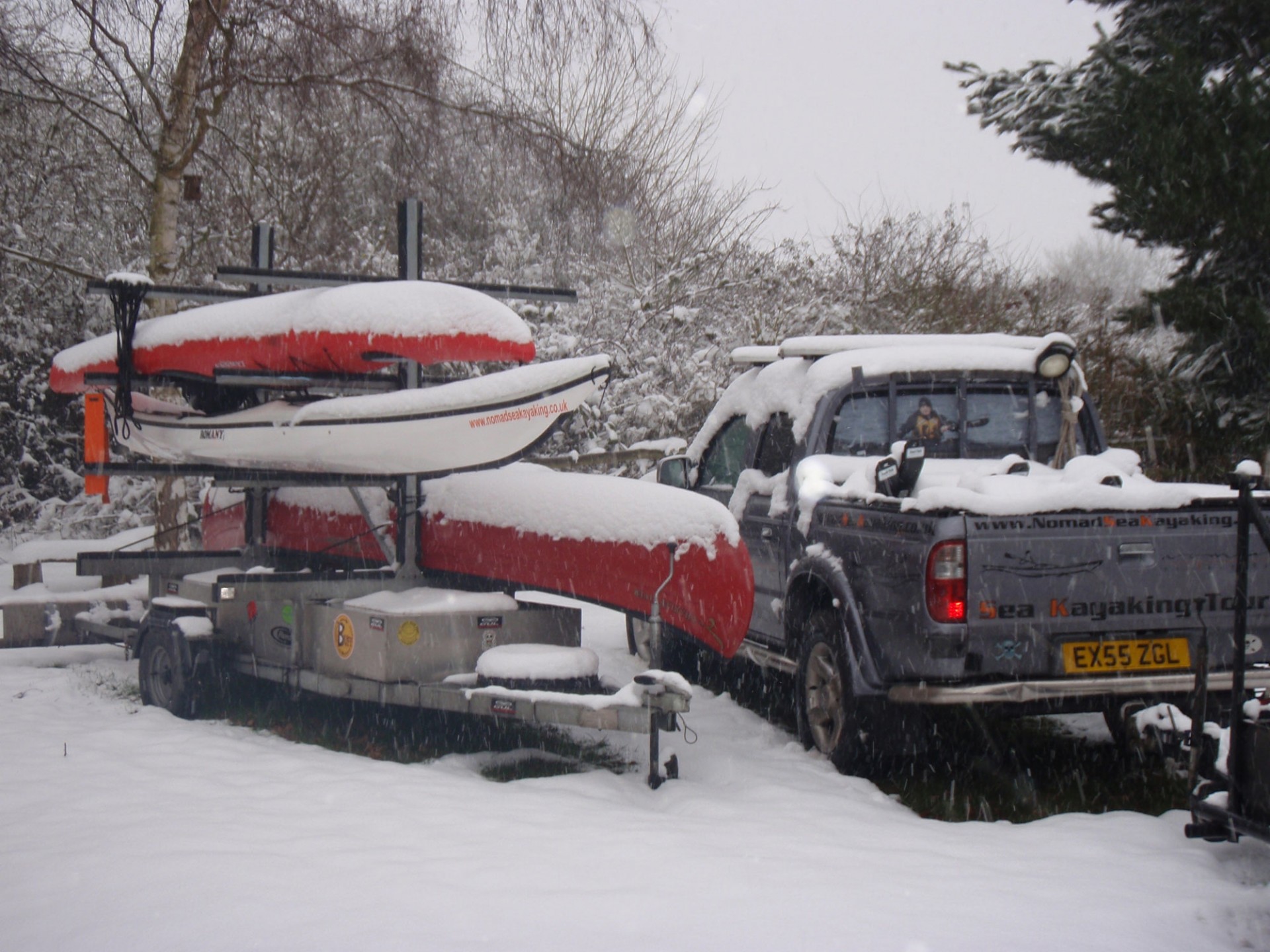 Kayaks on a trailer covered in snow