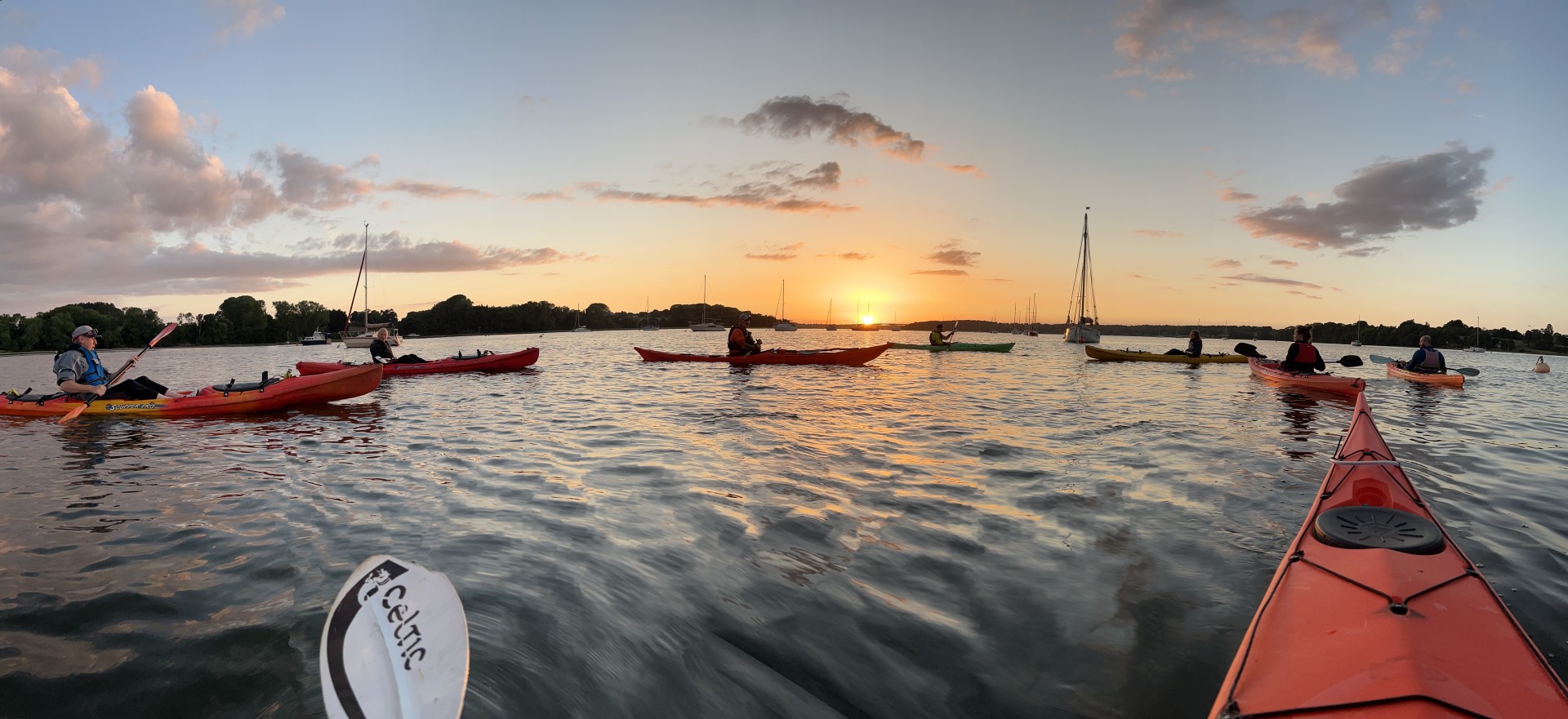 Sea kayakers on the Orwell estuary at sunset with NOMAD Sea Kayaking.