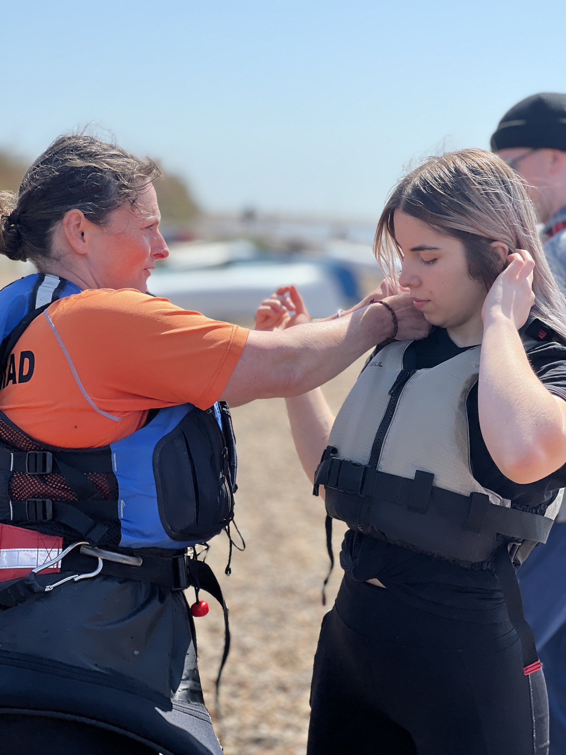 A NOMAD Sea Kayaking Guide adjusting guests buoyancy aid.